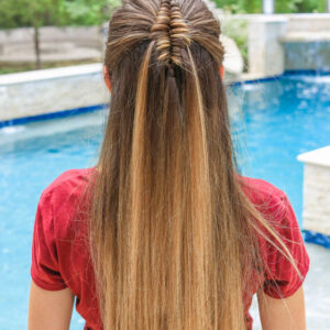 Back view of girl by the pool with long hair and showcasing long infinity braid