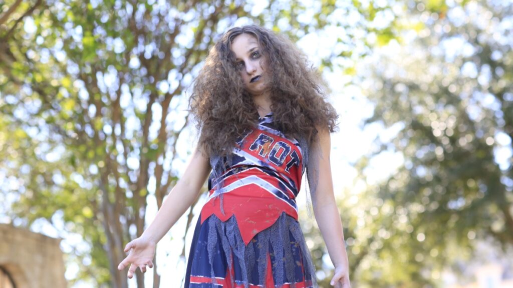 Young girl posing and dressed in "Zombie Cheerleader" Halloween Costume